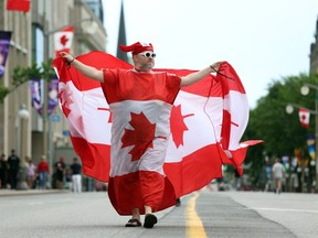 Ein Mann mit kanadischen Flaggen marschiert während der Feierlichkeiten zum Canada Day am 1. Juli 2022 in Ottawa, Kanada.