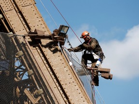 A worker is seen on the Eiffel tower during the 20th campaign of painting and stripping in Paris, France, July 5, 2022.