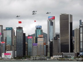 Helicopters carry Chinese flags over Hong Kong's Victoria Harbour on the 25th anniversary of the former British colony's handover to Chinese rule, July 1, 2022. There is a growing trend among China’s wealthy to move at least their money, if not themselves, out of the country.