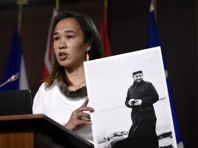 Nunavut NDP MP Mumilaaq Qaqqaq holds a photo of Fr. Johannes Rivoire, who is wanted in Canada for allegedly abusing children in Nunavut but now resides in France, July 8, 2021.