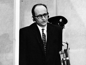 Nazi war criminal Adolf Eichmann standing in his bullet-proof dock during the first day of his trial in front of an Israeli court on April 11, 1961, in Jerusalem.
