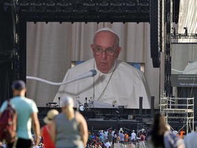 People watch Pope Francis speaking on a screen at the Citadelle de Québec in Quebec City, July 27, 2022.