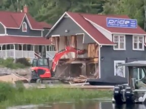A still from a video showing a Pride Marine Group building being torn apart by an excavator.