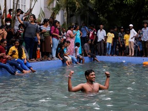 A man stands in the swimming pool at the President's house after demonstrators entered the building, after President Gotabaya Rajapaksa fled, amid the country's economic crisis, in Colombo, Sri Lanka July 10, 2022. REUTERS/Dinuka Liyanawatte