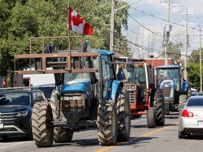Menschen, die Traktoren fahren, protestieren gegen eine geplante Veranstaltung mit Kanadas Premierminister Justin Trudeau, die am 15. Juli 2022 in Embrun, Ontario, Kanada, abgesagt wurde.