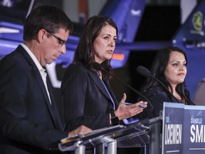 Danielle Smith, centre, speaks as Todd Loewen, left, and Rajan Sawhney listen during the Alberta UCP leadership candidate's debate in Medicine Hat, July 27, 2022.