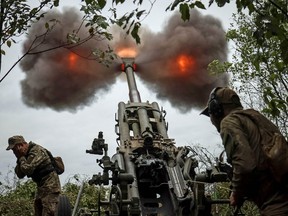 Ukrainian soldiers fire a shell from a M777 Howitzer at a front line in Kharkiv Region, Ukraine, July 21, 2022.