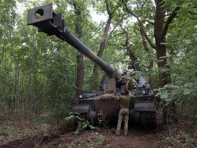 Ukrainian servicemen work next to a Polish-provided 155mm self-propelled tracked gun-howitzer Krab on the front line in the Donetsk region.