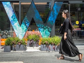 A woman walks past the W Toronto Hotel moniker at the newly minted hotels 90 Bloor Street East location unveiling, Thursday July 21, 2022.