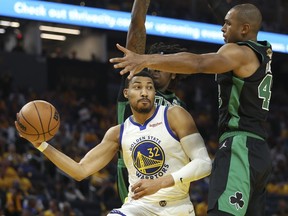 Golden State Warriors forward Otto Porter Jr. (32) passes the ball against Boston Celtics center Robert Williams III, rear, and center Al Horford during the second half of Game 5 of basketball's NBA Finals in San Francisco, Monday, June 13, 2022. The Toronto Raptors have signed Porter Jr., who was a key member of the Golden State Warriors' NBA championship team.