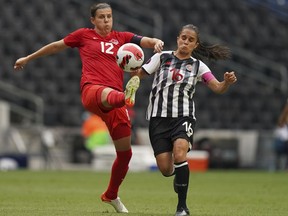 Canada's Christine Sinclair (12) and Costa Rica's Katherine Alvarado fight for the ball during a CONCACAF Women's Championship soccer match in Monterrey, Mexico, Monday, July 11, 2022.