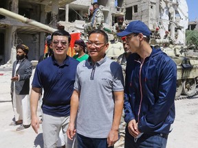 Chinese Ambassador Feng Biao poses for a picture with crew members in the Syrian capital Damascus on July 14, during the filming of a scene in a film produced by actor Jackie Chan.