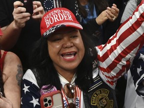 Mimi Israelah, center, cheers for Donald Trump inside the Alaska Airlines Center in Anchorage, Alaska, during a rally Saturday July 9, 2022. An investigation has been launched after a person believed to be an Anchorage, Alaska, police officer was shown in a photo with Israelah flashing a novelty "White Privilege card." The social media post caused concerns about racial equality in Alaska's largest city.
