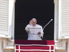 Pope Francis waves during the Angelus noon prayer from the window of his studio overlooking St. Peter's Square, at the Vatican, Wednesday, June 29, 2022.