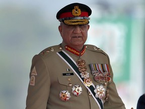 FILE - Pakistan's Army Chief General Qamar Javed Bajwa arrive to attend a military parade to mark Pakistan National Day in Islamabad, Pakistan, Wednesday, March 23, 2022. Officials say Pakistan's powerful army chief in a rare move this week, Saturday, July 30, contacted Washington, urging U.S. authorities to use their influence to secure an early release of a key $1.7 billion installment from the International Monetary Fund. The latest development comes as Islamabad struggles to stave off a deepening economic crisis.