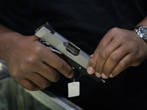 Sales associate Elsworth Andrews shows a handgun to a customer at Burbank Ammo & Guns in Burbank, Calif., Thursday, June 23, 2022. The Supreme Court has ruled that Americans have a right to carry firearms in public for self-defense, a major expansion of gun rights. The court struck down a New York gun law in a ruling expected to directly impact half a dozen other populous states.