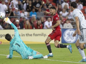 Toronto FC midfielder Jonathan Osorio (centre) kicks the ball over San Jose Earthquakes goalkeeper JT Marcinkowski (1) to score his team's second goal during second half MLS action in Toronto on Saturday July 9, 2022.