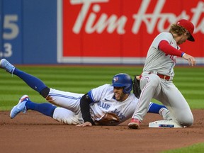 Toronto Blue Jays centre fielder George Springer (4) steals second base during first inning interleague MLB action against the Philadelphia Phillies second baseman Bryson Stott (5) in Toronto on Tuesday, July 12, 2022. CANADIAN PRESS/Christopher Katsarov