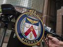 Das Emblem der Toronto Police Services wird am Dienstag, den 17. Mai 2022, während einer Pressekonferenz in der TPS-Zentrale in Toronto fotografiert. Anklagen gegen einen Mann aus Toronto, die erhoben wurden, nachdem im vergangenen Monat eine Frau in einem Transitbus in Brand gesteckt worden war, wurden im Anschluss verbessert der Tod der Frau.