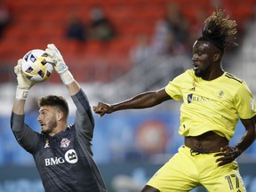 Toronto FC goalkeeper Alex Bono (25) makes a save as Nashville SC forward C.J. Sapong (17) looks on during their MLS soccer game in Toronto, Saturday, September 18, 2021.