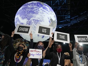 FILE - Climate activist Vanessa Nakate, second right, and other activists engage in a 'Show US The Money' protest at the COP26 U.N. Climate Summit in Glasgow, Scotland, Nov. 8, 2021. Richer countries failed to keep a $100 billion-a-year pledge to developing nations to help them achieve their climate goals, according to an analysis by the Organization for Economic Cooperation and Development, or OECD, released Friday, July 29, 2022.