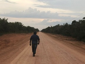 A man walks down an unpaved stretch of highway BR-319 in the Brazilian Amazon between the cities of Manaus and Porto Velho on Aug. 10, 2018. In a decision that critics have labeled dangerous, Brazil's government granted a preliminary environmental permit for the paving of the controversial highway that cuts through one of the Amazon rainforest's most preserved areas.