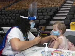 Ein Kind bereitet sich darauf vor, am Sonntag, den 12. Dezember 2021, in einer Kinderimpfklinik in der Scotiabank Arena in Toronto seinen COVID-19-Impfstoff zu erhalten.