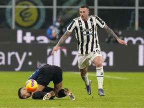 Juventus' Federico Bernardeschi, right, challenges for the ball with Inter Milan's Joaquin Correa during the Italian Super Cup final soccer match between Inter Milan and Juventus at the San Siro Stadium, in Milan, Italy, Wednesday, Jan. 12, 2022.