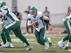 Saskatchewan Roughriders quarterback Cody Fajardo, centre, scrambles in the pocket during the first half of CFL action against the Toronto Argonauts at Acadia University in Wolfville, N.S., Saturday, July 16, 2022.