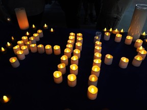 Candles form the letters H P are seen on the table during a vigil at Sunset Woods Park for the victims of Monday's Highland Park's Fourth of July parade, Thursday, July 7, 2022, in Highland Park, Ill.