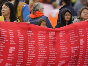 Indigenous people hold up a banner while waiting for Pope Francis during his visit to Maskwaci, the former Ermineskin Residential School, Monday, July 25, 2022, in Maskwacis, Alberta. Pope Francis traveled to Canada to apologize to Indigenous peoples for the abuses committed by Catholic missionaries in the country's notorious residential schools.