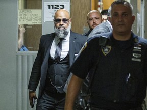 Steven Lopez, left, exits the courtroom following a hearing at the Supreme court, Monday, July 25, 2022, in New York. Lopez, a co-defendant of the so-called Central Park Five, whose convictions in a notorious 1989 rape of a jogger were thrown out more than a decade later, had his conviction on a related charge overturned Monday. Lopez was exonerated in response to requests by both Lopez's attorney and prosecutors.
