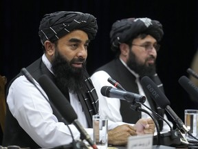 Zabiullah Mujahid, left, the spokesman for the Taliban government, speaks during a press conference in Kabul, Afghanistan, Thursday, June 30, 2022. Afghanistan's Taliban rulers held a gathering Thursday of some 3,000 Islamic clerics and tribal elders for the first time since seizing power in August, urging them to advise them on running the country. Women were not allowed to attend.