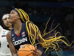 UConn's Aaliyah Edwards drives past South Carolina's Destanni Henderson during the first half of a college basketball game in the final round of the Women's Final Four NCAA tournament Sunday, April 3, 2022, in Minneapolis. At a recent meeting of Canada's U23 men's and women's basketball teams, players were asked to raise hands if they'd ever played for Canada at home. Two of the 36-odd players assembled put up their hands.
