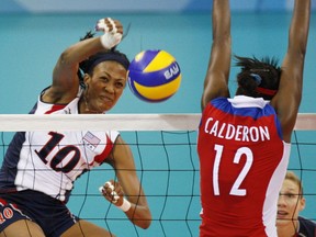FILE - USA's Kim Glass, left, jumps for the ball with Cuba wing spiker Rosir Calderon during a women's Volleyball match at the Olympics in Beijing on Aug. 11, 2008. A former Olympic volleyball player was attacked Friday, July 8, 2022, in downtown Los Angeles when a man threw a metal object at her face in an assault that fractured bones in her face and left one of her eyes swollen shut, the athlete said in videos posted to social media. Glass, a silver medalist at the 2008 Beijing Olympics, had been leaving a lunch on Friday afternoon when she saw a man run up with something in his hand.