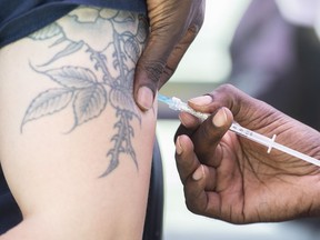 A man receives a monkeypox vaccine at an outdoor walk-in clinic in Montreal, Saturday, July 23, 2022. The British Columbia government says monkeypox vaccine is being made available to eligible patients in most areas of the province.