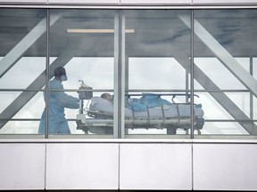 A health-care worker pushes a patient at a hospital on Thursday, July 14, 2022. The B.C. Court of Appeals has dismissed a challenge that a patient's right to pay for services outside of the health-care system violates their rights. THE CANADIAN PRESS/Graham Hughes