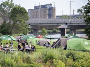 People are shown next to tents during a Parks Canada "Learn to Camp" event in Montreal, Saturday, July 23, 2022.