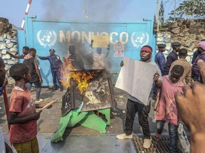 A resident holds a placard reading ''MONUSCO get out without delay'' as they protest against the United Nations peacekeeping force (MONUSCO) deployed in the Democratic Republic of the Congo, in Goma, Monday, July 25, 2022. Demonstrators said they were protesting against the rise of insecurity and inaction of the UN in the region.