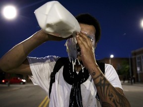 FILE - In this Friday, May 29, 2020 file photo, protestors wash out tear gas with milk as violence breaks out following a peaceful protest in support of George Floyd in Des Moines. An assistant attorney general in Iowa is suing the city of Des Moines and its police chief over his arrest during a June 2020 racial justice protest, alleging he was tackled, pepper-sprayed and handcuffed for no reason.