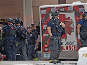 Law enforcement wait outside after a deadly shooting Sunday, July 17, 2022, at the Greenwood Park Mall, in Greenwood, Ind.