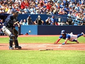 Toronto Blue Jays' starting pitcher Bo Bichette slides safely into home ahead of the throw to Tampa Bays Rays' catcher Rene Pinto in first inning American League baseball action in Toronto, Saturday, July 2, 2022.