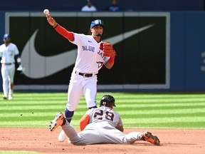 Toronto Blue Jays second baseman Santiago Espinal, top, throws to first base to put out Detroit Tigers' Miguel Cabrera after forcing out Javier Baez at second base in the fourth inning of American League baseball action in Toronto, Saturday, July 30, 2022.