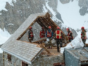 Workers dismantle the Abbot Pass Refuge Cabin in this undated handout photo. Parks Canada says a hut built by Swiss guides a century ago in the Rockies has been substantially removed. Only a piece of wall, some stone steps and a plaque about the Abbot Pass Refuge Cabin remain at the site that straddles the Continental Divide and the Alberta-British Columbia boundary. The hut was designated a national historic site in 1992. Parks Canada says it had to be dismantled because of erosion.
