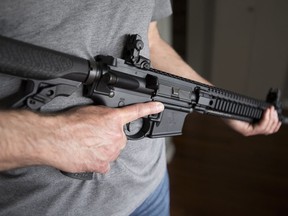 Ein Inhaber einer eingeschränkten Waffenlizenz hält am 1. Mai 2020 eine AR-15 in seinem Haus in Langley, BC.