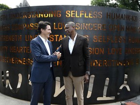 Prime Minister Justin Trudeau shakes hands with Masai Ujiri, President of the Toronto Raptors and Giants of Africa Co-founder, at the presentation of the Humanity Art Installation at Major's Hill Park in Ottawa, on Friday, July 8, 2022. The installation, which is made of steel and comprises 35 words that reflect what humanity means to Ujiri, was inspired by Nelson Mandela's fight for equality.