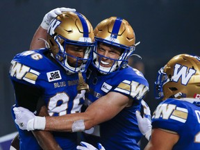 Winnipeg Blue Bombers' Carlton Agudosi (86) and Greg Ellingson (2) celebrate Agudosi's game winning touchdown against the Calgary Stampeders during the second half of CFL action in Winnipeg, Friday, July 15, 2022. Ellingson, Edmonton receiver Kenny Lawler and Hamilton quarterback Dane Evans have been named the top performers for Week 6 of the 2022 CFL season.