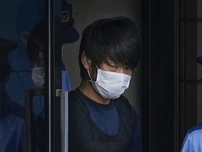 FILE - Tetsuya Yamagami, the alleged assassin of Japan's former Prime Minister Shinzo Abe, gets out of a police station in Nara, western Japan, on July 10, 2022, on his way to local prosecutors' office. The suspect will be detained until late November for mental evaluation so prosecutors can determine whether to formally press charges and sent him to trial for murder, officials said Monday.
