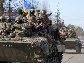 FILE - Ukrainian soldiers ride a tank through the town of Trostsyanets, some 400 km eastern of capital Kyiv, Ukraine, Monday, March 28, 2022. Ukraine's Defense Minister Hanna Malyar said recently that the Russian forces were firing 10 times more ammunition than the Ukrainian military.