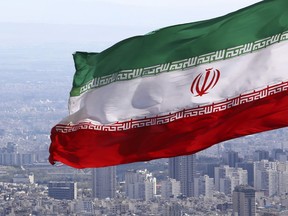 FILE - Iran's national flag waves in Tehran, Iran, March 31, 2020. Iranian media reported on Wednesday July 6, 2022, that the country's paramilitary Revolutionary Guard has accused the deputy ambassador of the United Kingdom and other foreigners in the country of "espionage" and taking soil samples from prohibited military zones.